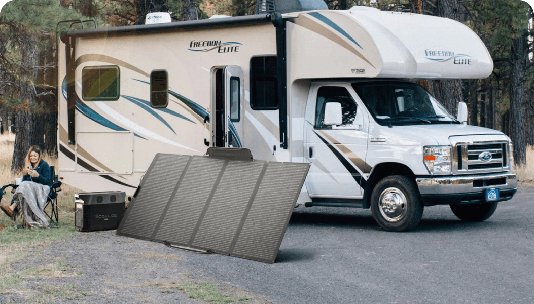 Next to an RV, an EcoFlow 400W Portable Solar Panel charges a DELTA Pro while a woman tops up her phone using the DELTA Pro.