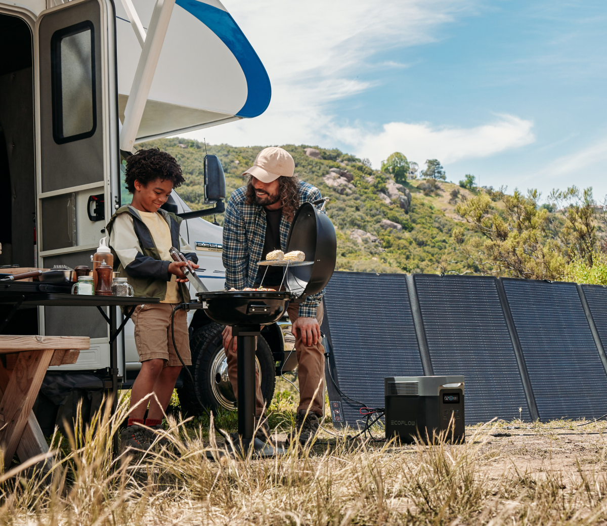 RV outdoors with man and child grilling food. DELTA 2 Max is charging via a solar panel.