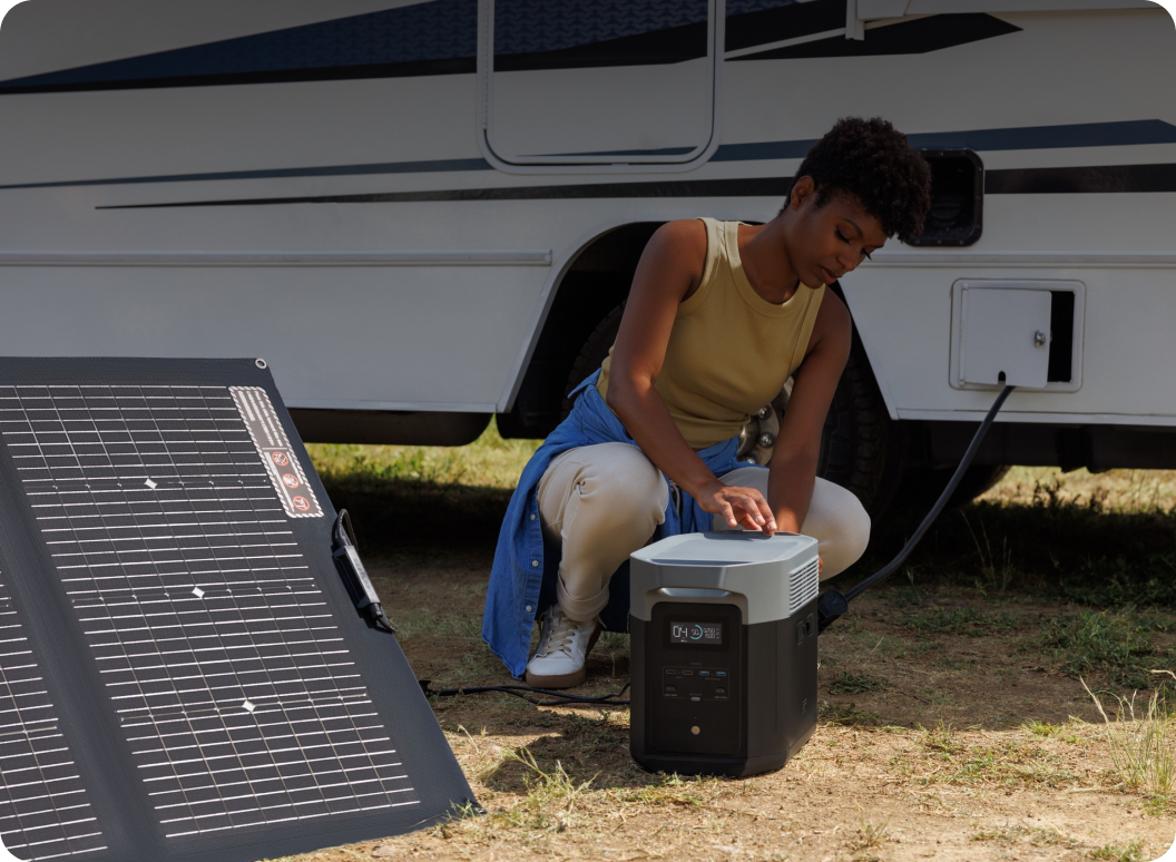 A woman connects a DELTA Pro to an EcoFlow solar panel and to her RV.